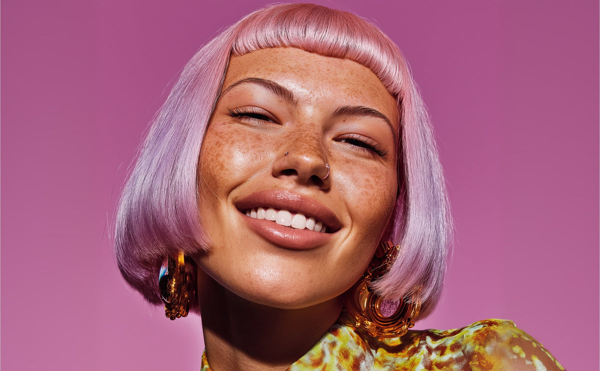 Smiling woman with pastel pink bob haircut and colorful outfit against pink studio background