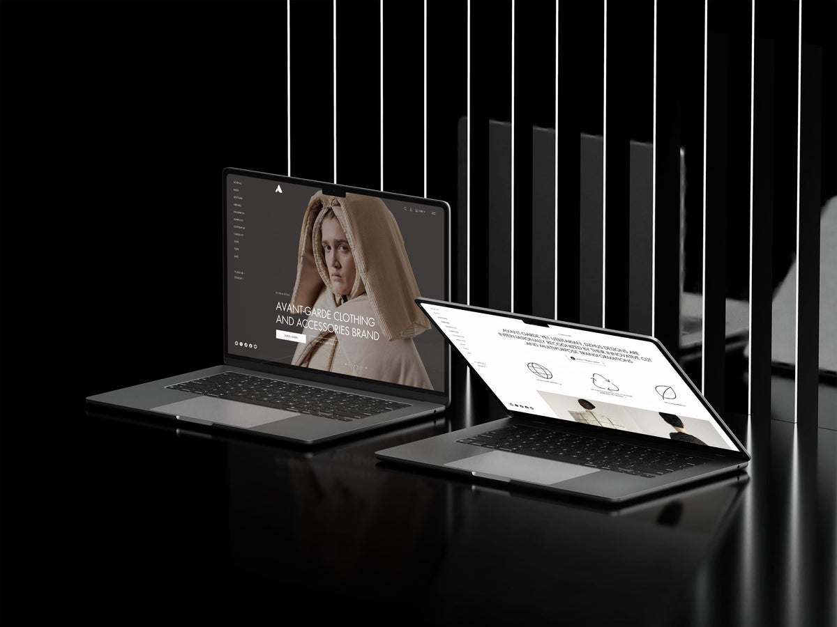 Two laptops on a black surface with a blurred background