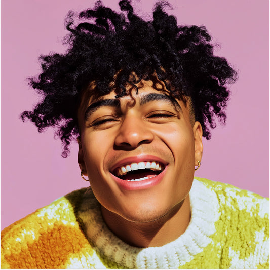 Person wearing a colorful sweater with a pink background