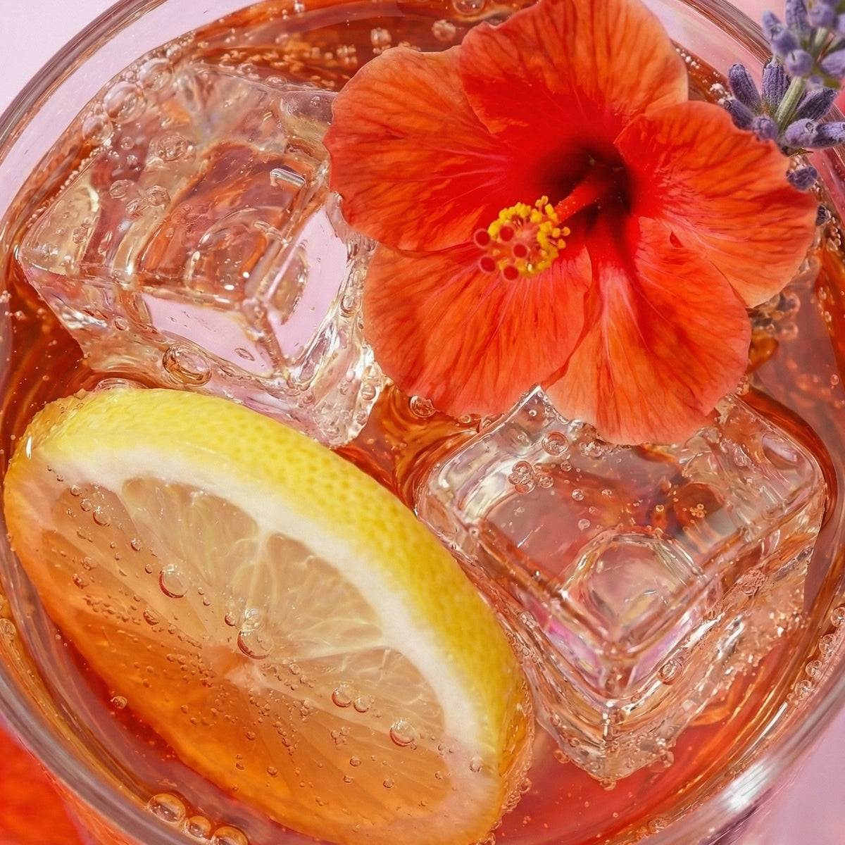Glass of iced tea with lemon slice, red flower, and ice cubes.