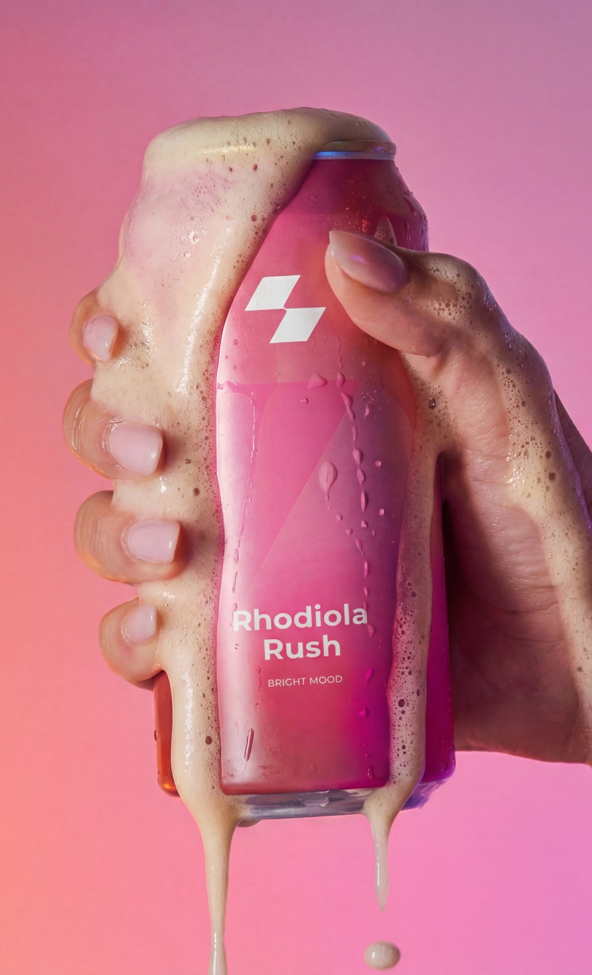 Bottle of Rhodiola Rush with a hand holding it against a pink background