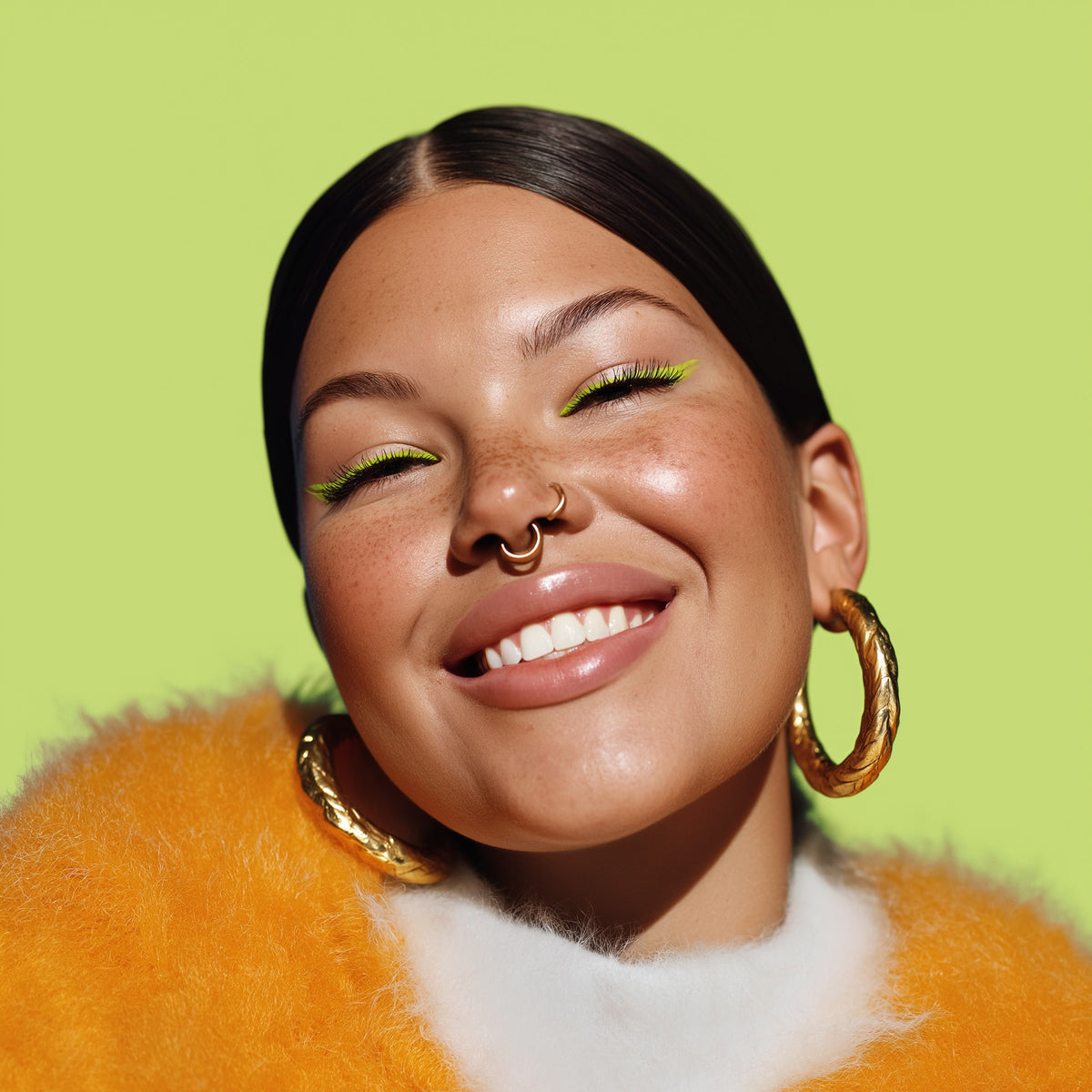 Woman with gold hoop earrings and green eyeshadow against a green background