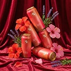 Red hair care products with flowers on a red fabric background