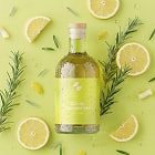 Green bottle of olive oil with lemon slices and rosemary on a green background