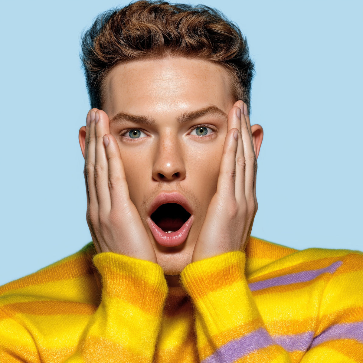 Person wearing a yellow sweater with a surprised expression on a light blue background
