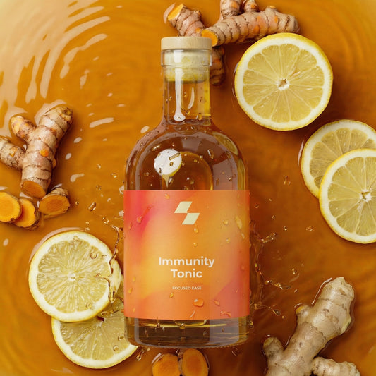Bottle of 'Immunity Tonic' with turmeric and lemon slices on a warm-toned background