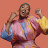Smiling woman in colorful fashion outfit with bold makeup