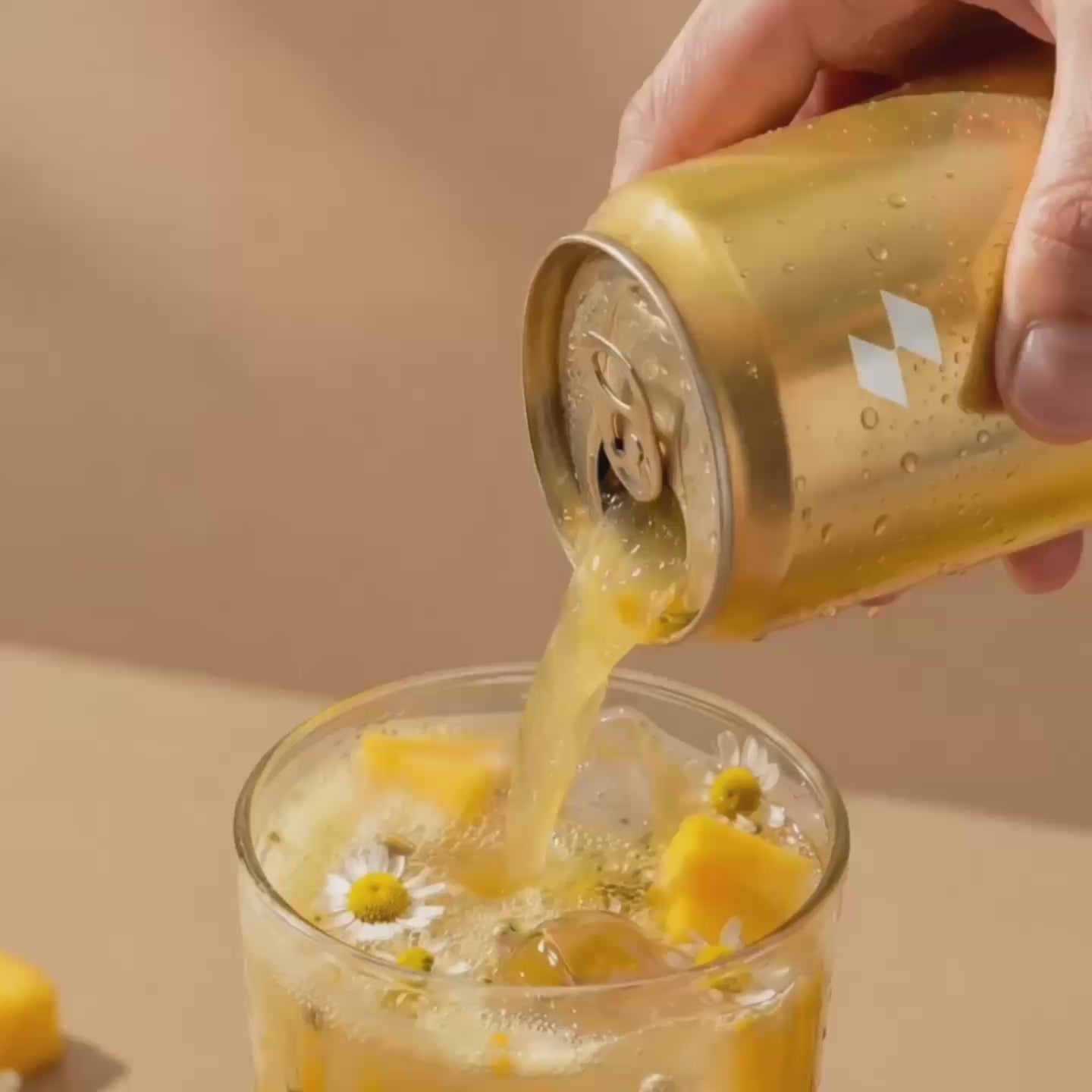 Pouring tropical sparkling drink over ice with chamomile flowers